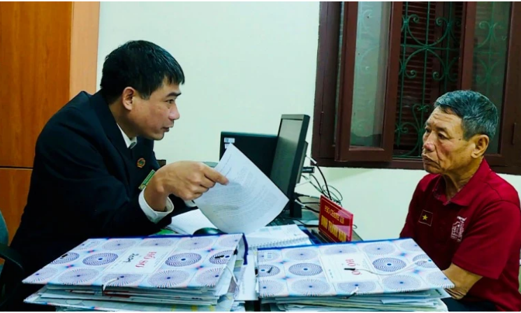 Cán bộ Tòa án nhân dân huyện Lý Nhân, tỉnh Hà Nam giải thích quy định pháp luật cho người dân. (Ảnh HẢI ĐĂNG)