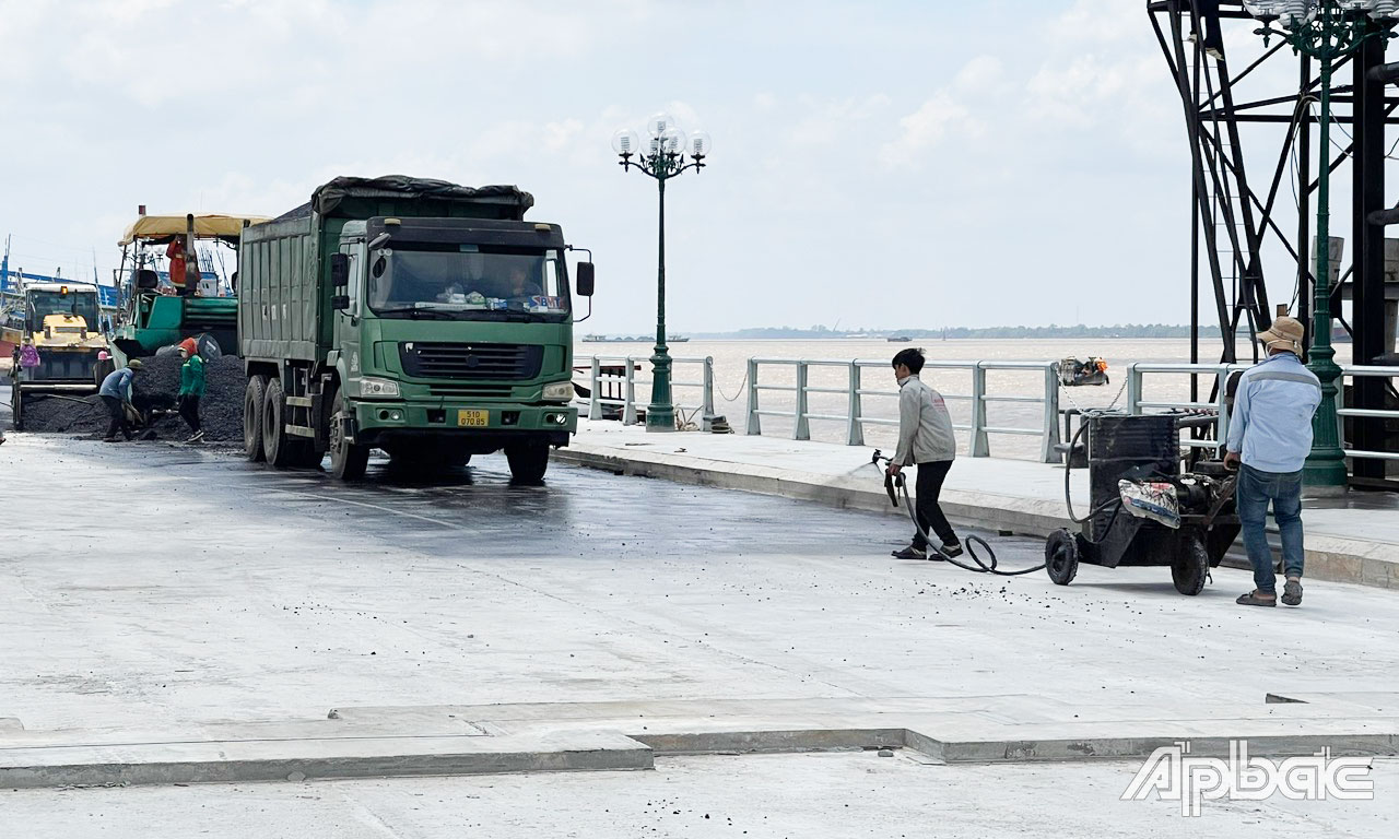 Đơn vị thi công tiến hành thảm nhựa phần kè của gói thầu.