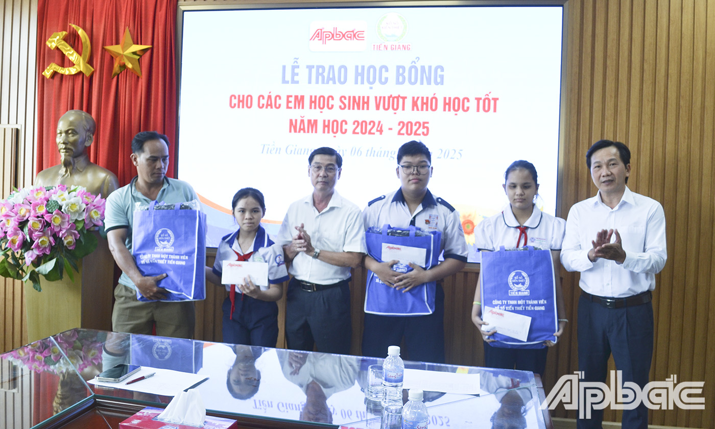 Đồng chí Nguyễn Trọng Tấn, Phó Tổng biên tập Báo Ấp Bắc và ông Trần Văn An, Giám đốc Công ty TNHH MTV Xổ số kiến thiết Tiền Giang trao học bổng cho 3 em học sinh vượt khó học tốt.