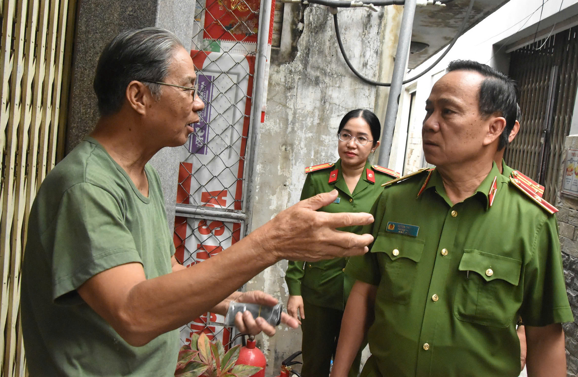 Thiếu tướng Huỳnh Thới An trao đổi với hộ dân gần vụ cháy nhà. Ảnh: A.S