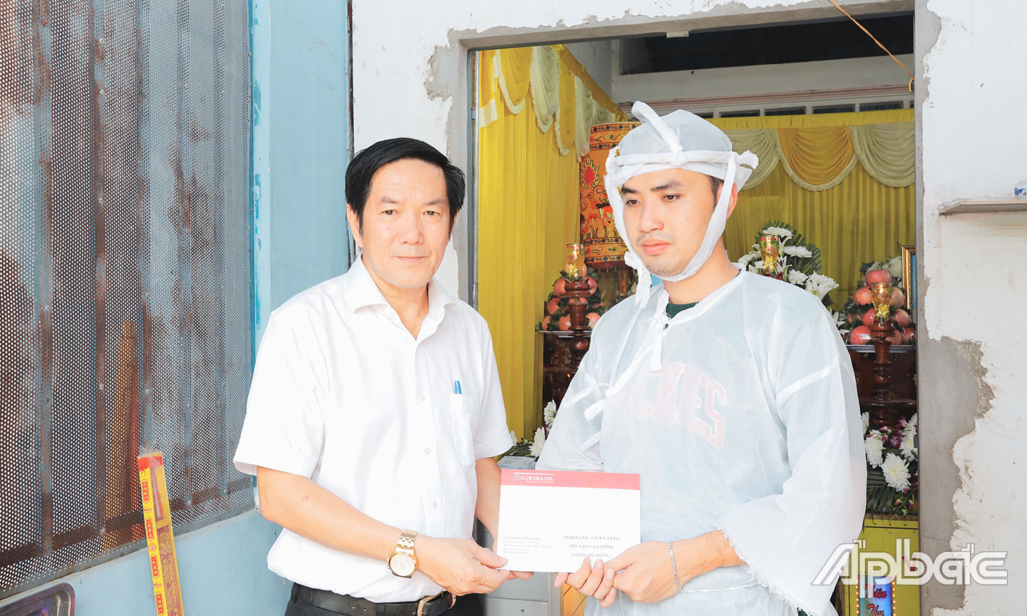 Cháu Nguyễn Khánh Duy nhận số tiền hỗ trợ 15 triệu đồng từ Giám đốc Agribank chi nhánh tỉnh Tiền Giang Trương Văn Đoàn