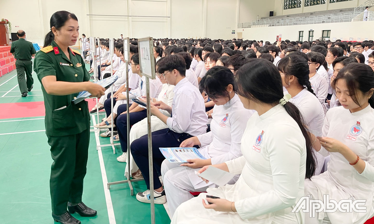 Cấp phát tờ rơi tuyên truyền tuyển sinh các trường quân đội, công an năm 2025 cho học sinh.