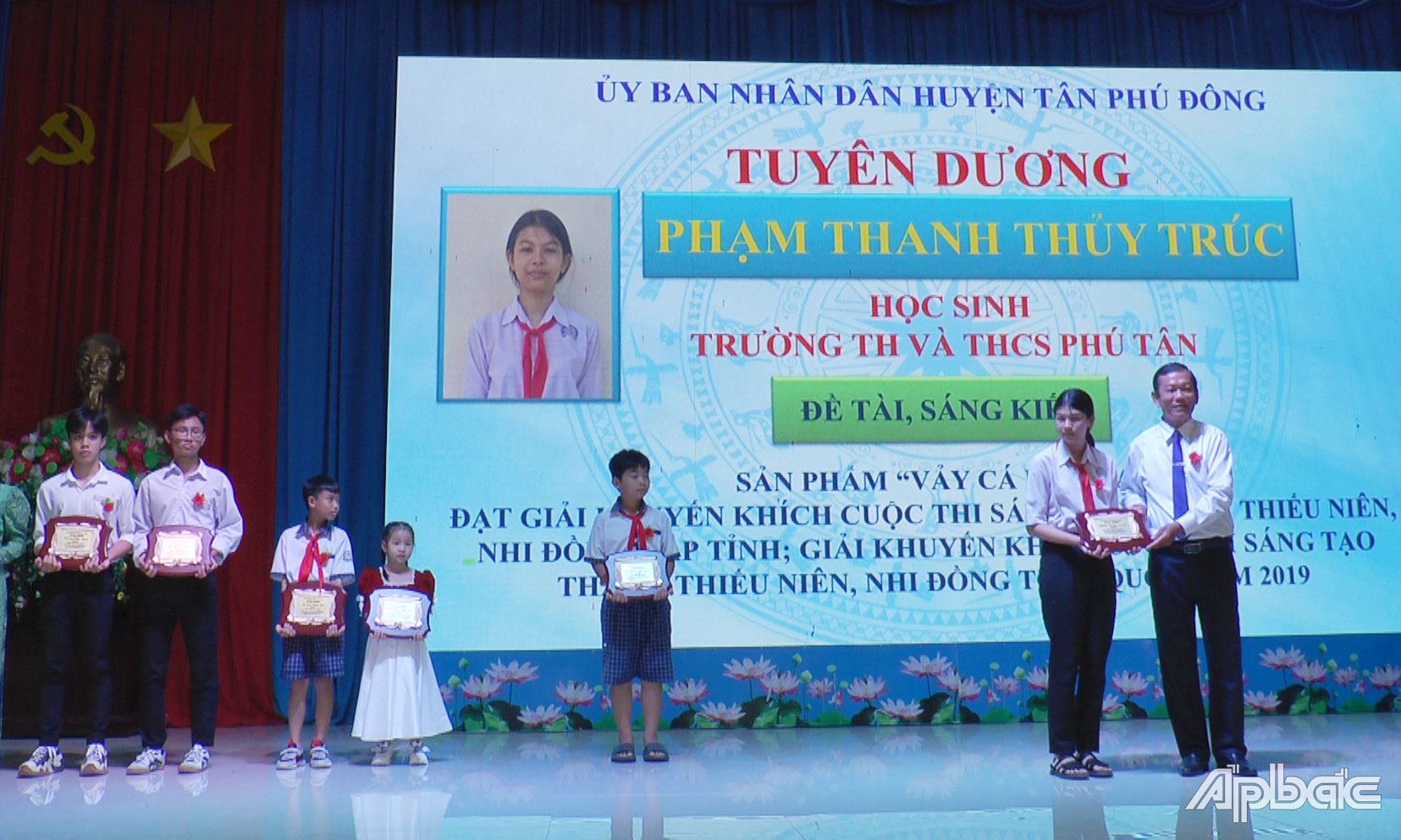Bí thư Huyện ủy, Chủ tịch UBND huyện Tân Phú Đông Bùi Thái Sơn trao tặng biểu trưng tuyên dương gương sáng trong đổi mới sáng tạo cho em Phạm Thanh Thủy Trúc.
