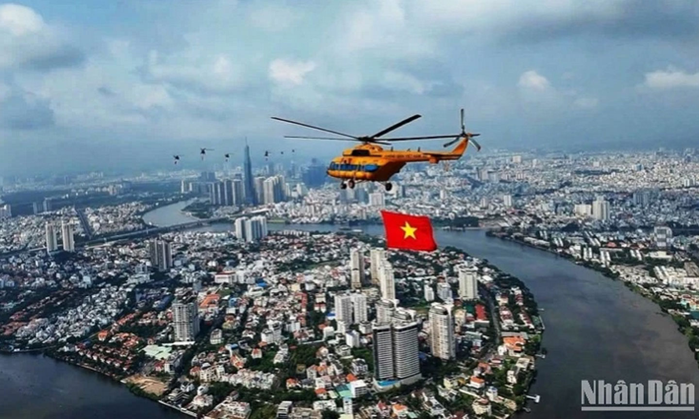 Trực thăng tập luyện bay kéo cờ trên bầu trời thành phố Hồ Chí Minh. (Ảnh: Khiếu Minh)