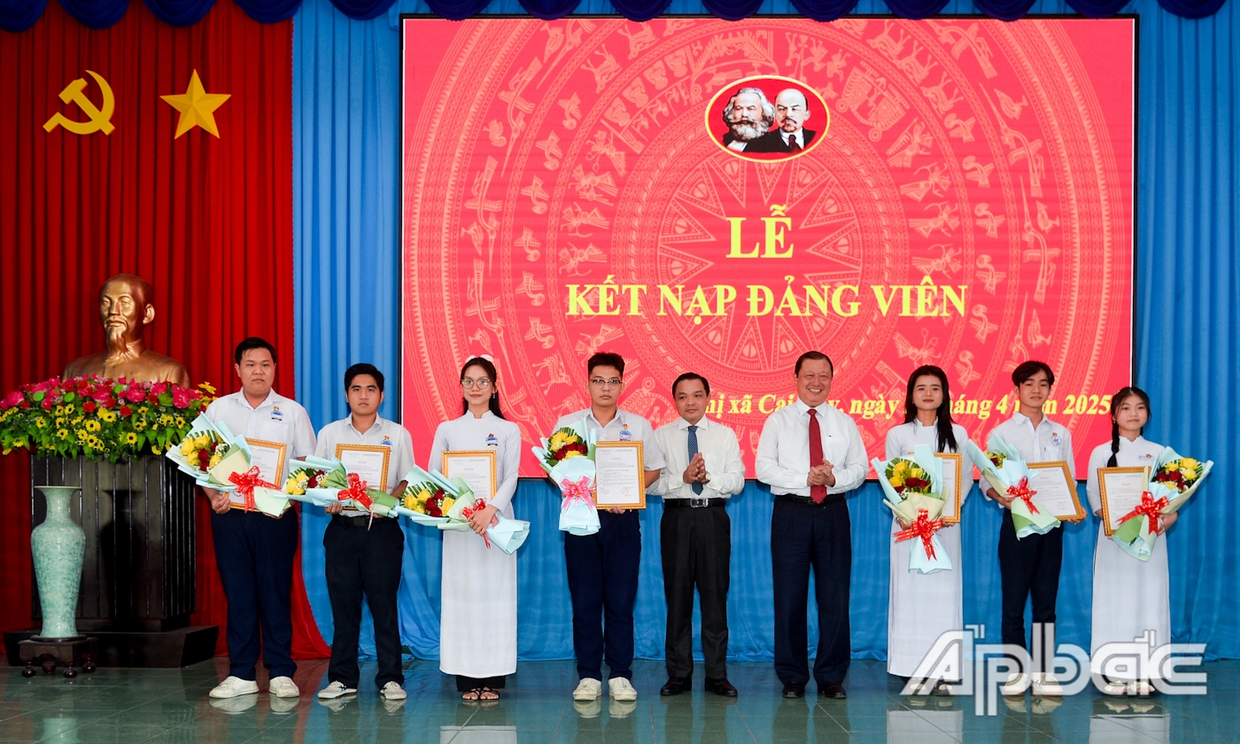 Thường trực Thị ủy trao Quyết định kết nạp Đảng và tặng hoa chúc mừng các em học sinh.