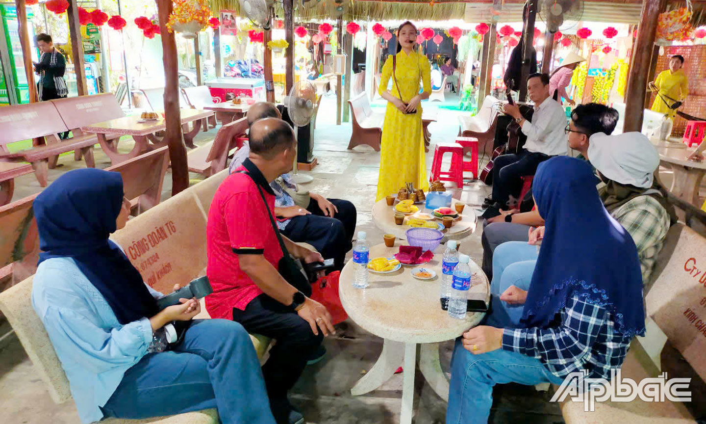 Du khách thưởng thức đờn ca tài tử, ăn trái cây tại cù lao Thới Sơn. 