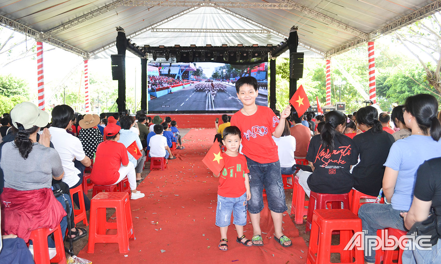 Người dân theo dõi buỗi Lễ kỷ niệm 50 năm Ngày Giải phóng miền Nam, thống nhất đất nước qua màn hình LED cỡ lớn tại Công viên Tết Mậu Thân (TP. Mỹ Tho).                                           Ảnh: HỮU THÔNG