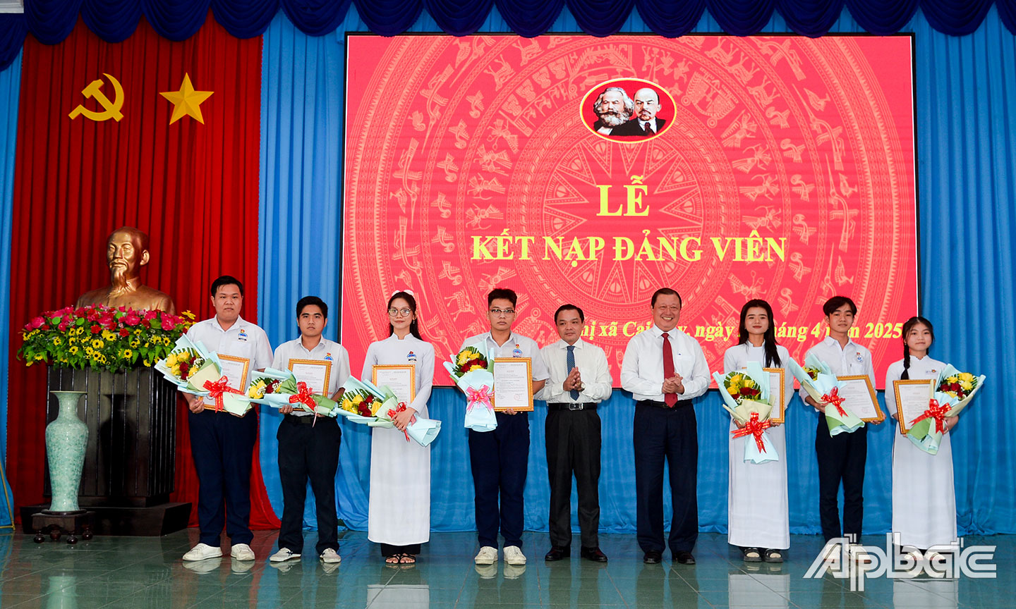 Thường trực Thị ủy trao Quyết định kết nạp Đảng và tặng hoa chúc mừng các em học sinh ưu tú được kết nạp vào Đảng.