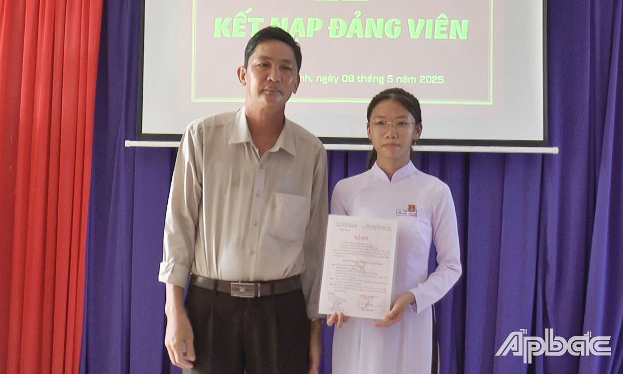 Đồng chí Châu Hoàng Hải, Bí thư Chi bộ 1 thuộc Đảng bộ Trường THCS và THPT  Phú Thạnh trao quyết định kết nạp đảng cho đồng chí Phạm Hồng Loan.