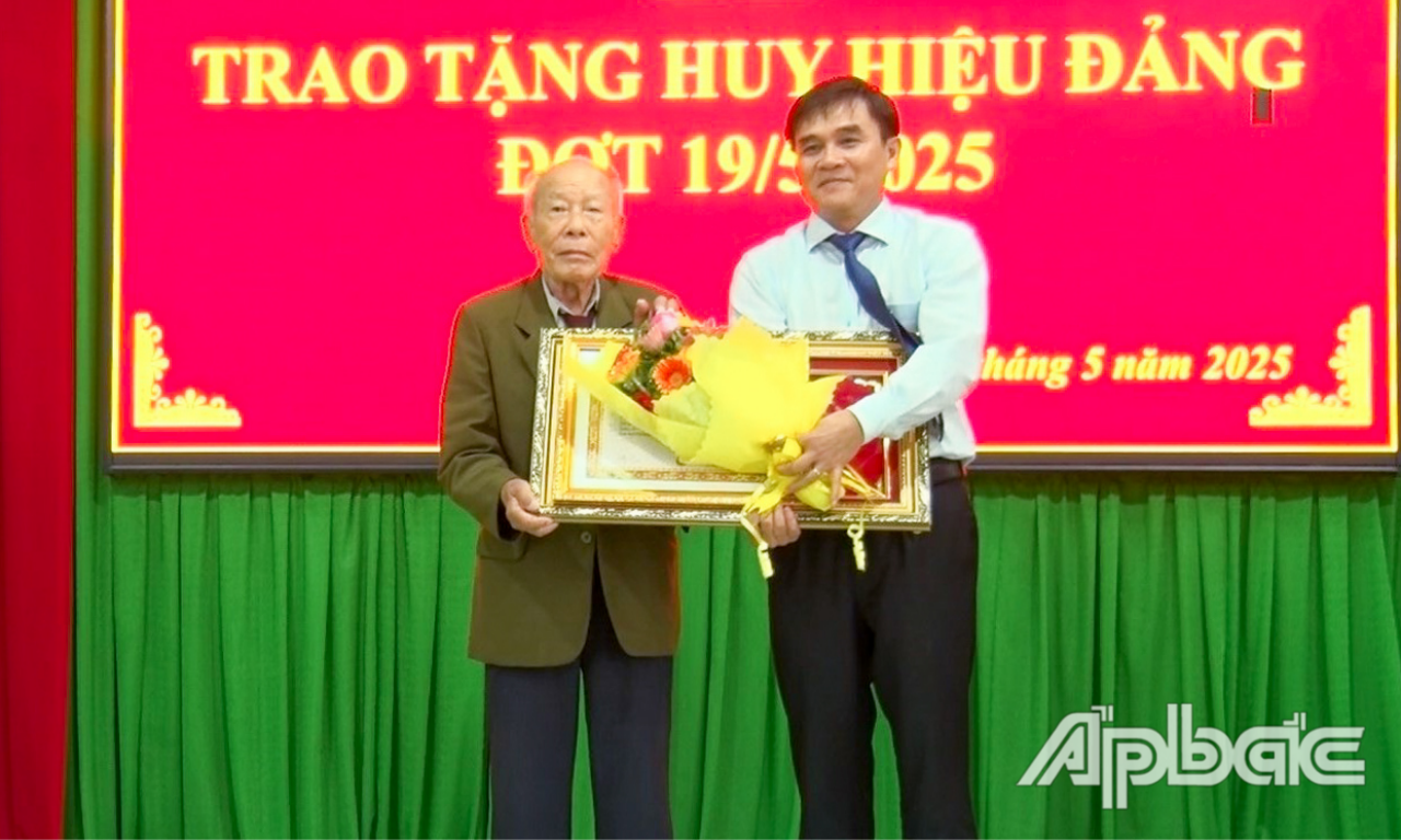 Đồng chí Nguyễn Văn Mười trao Huy hiệu 75 năm tuổi Đảng cho đảng viên Đặng Nam Chi.