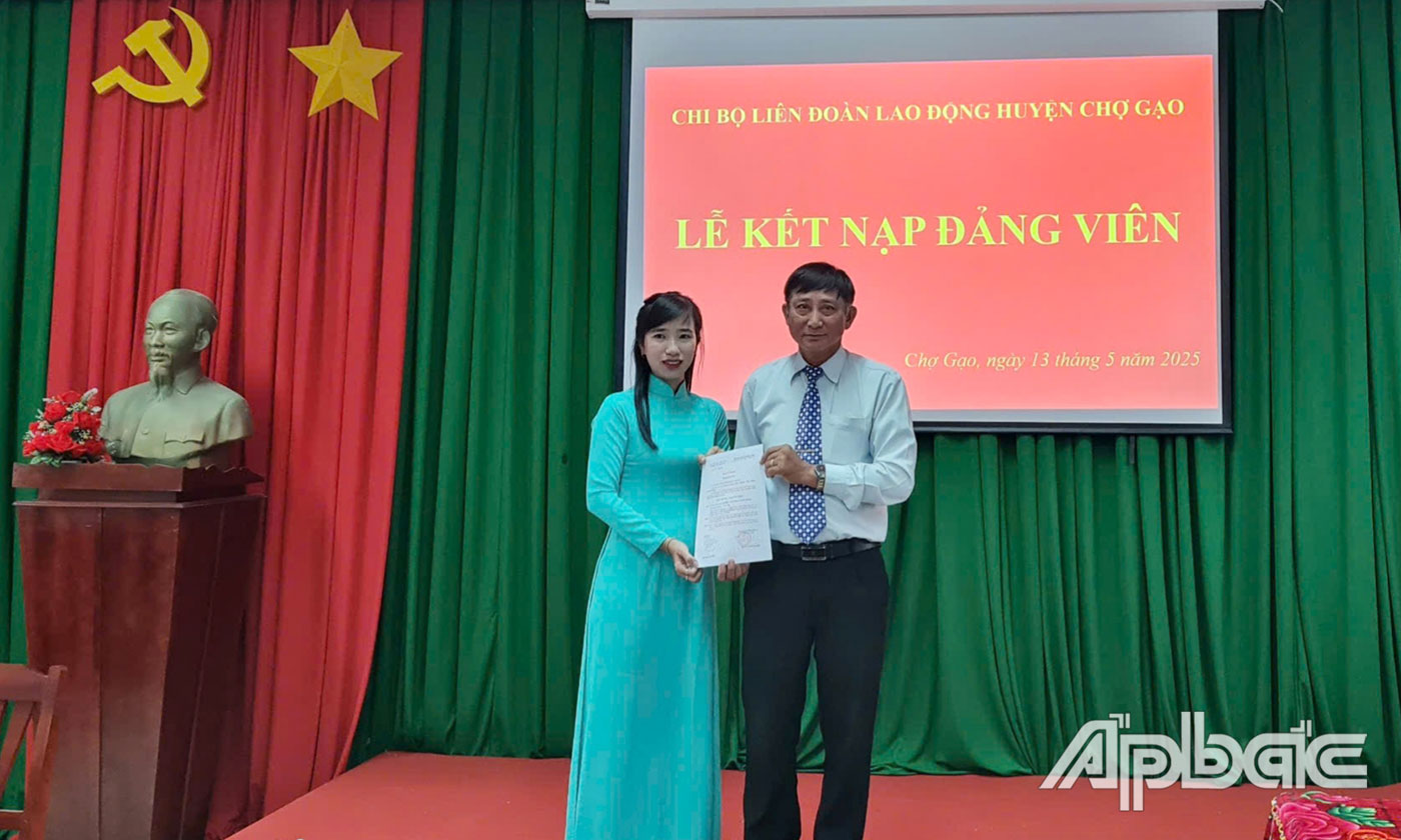 Đồng chí Lê Văn Rỡ, Bí thư Chi bộ Liên đoàn Lao động huyện Chợ Gạo trao quyết định kết nạp Đảng cho đồng chí Nguyễn Trần Thụy Huyền Trang.