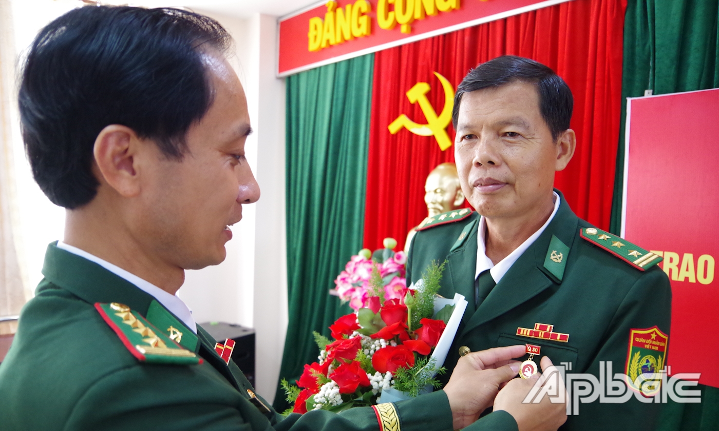 Đại tá Trần Chí Cường, Ủy viên Ban Thường vụ Đảng ủy, Phó Chỉ huy trưởng kiêm Tham mưu trưởng BĐBP tỉnh Tiền Giang gắn Huy hiệu 30 năm tuổi Đảng cho Thượng tá Nguyễn Văn Tiến.