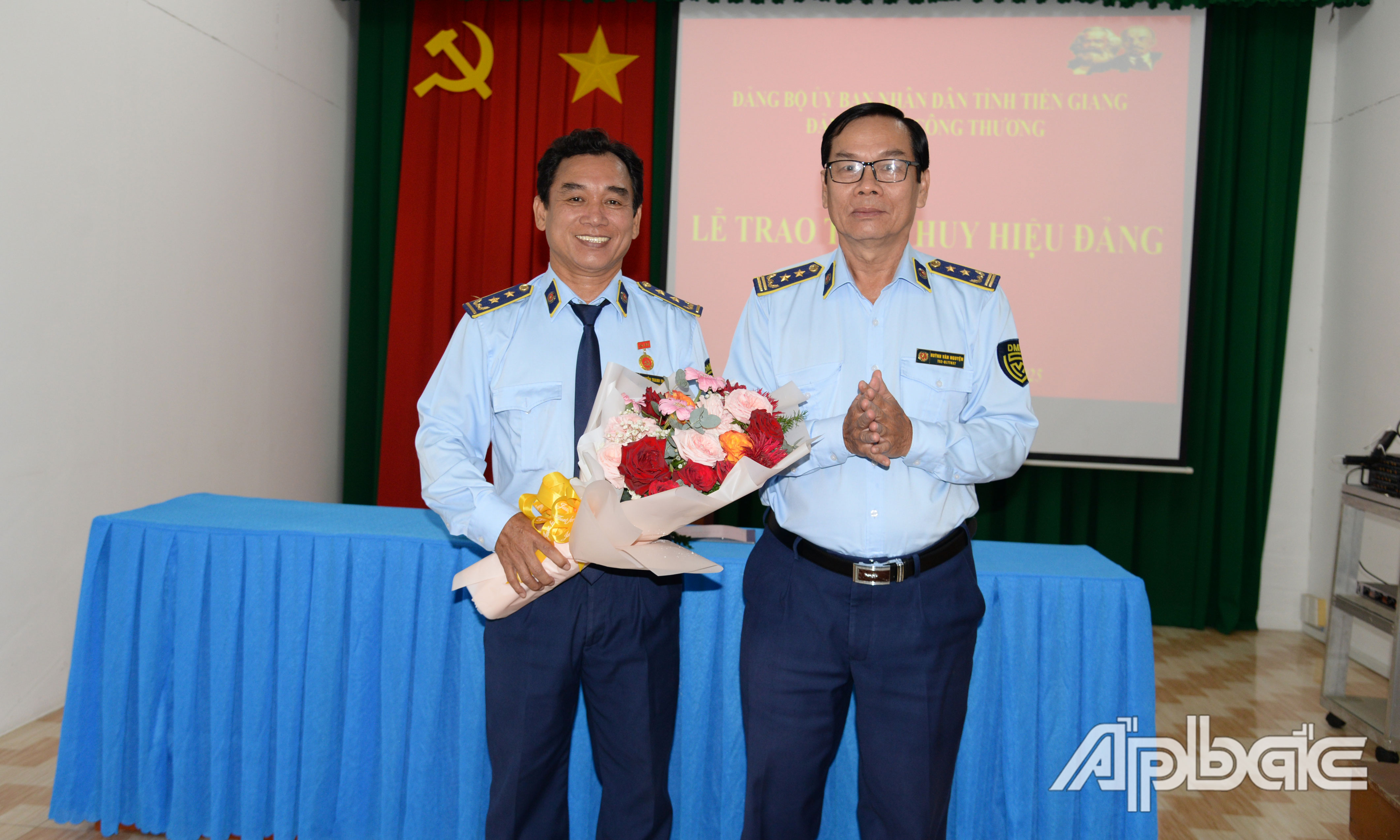 Chi Cục trưởng Chi cục Quản lý thị trường tỉnh Tiền Giang Huỳnh Văn Nguyện tặng hoa chúc mừng đồng chí Nguyễn Thanh Trưng.