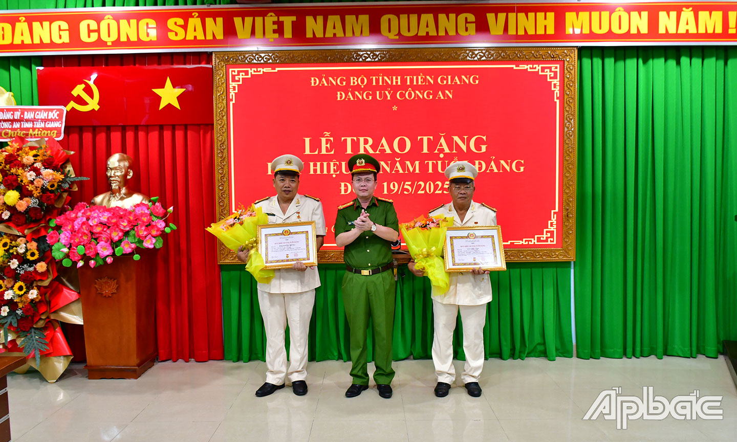Đại tá Nguyễn Minh Tân, Ủy viên Ban Thường vụ Đảng ủy, Phó Giám đốc Công an tỉnh trao Huy hiệu 30 năm tuổi Đảng cho đồng chí Võ Văn Lập và đồng chí Phạm Văn Dũng. Ảnh Đặng Thanh